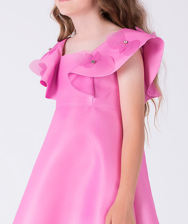 Close-up of ruffle shoulder detailing with floral appliqués and crystal-like accents on a luxury girls occasion dress
