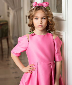 Luxury pink girls’ special occasion dress in structured matte satin with delicate flower details at the shoulders