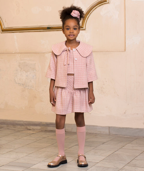 Girl wearing Mama Luma pink bouclé tweed jacket with matching skirt — luxury occasionwear for weddings, Christmas and Easter celebrations