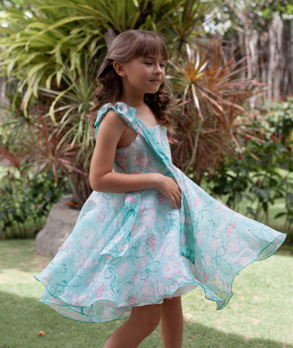 Girl twirling in a mint floral summer occasion dress
