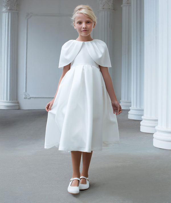 Girls elegant ivory dress with soft cape-style overlay and flowing midi skirt, designed for flower girl roles, weddings, christenings, and special formal occasions, available in sizes 3–12
