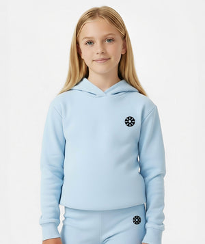 Girl wearing a light blue hoodie with a minimalist chest emblem, styled for everyday wear, school days, and casual active looks, available in sizes 3–14