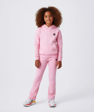 Front-facing lifestyle image of a girl wearing a pink hoodie with coordinating jogger pants, styled for calm everyday outfits, school-ready comfort, and relaxed athleisure wear, available in sizes 3–14