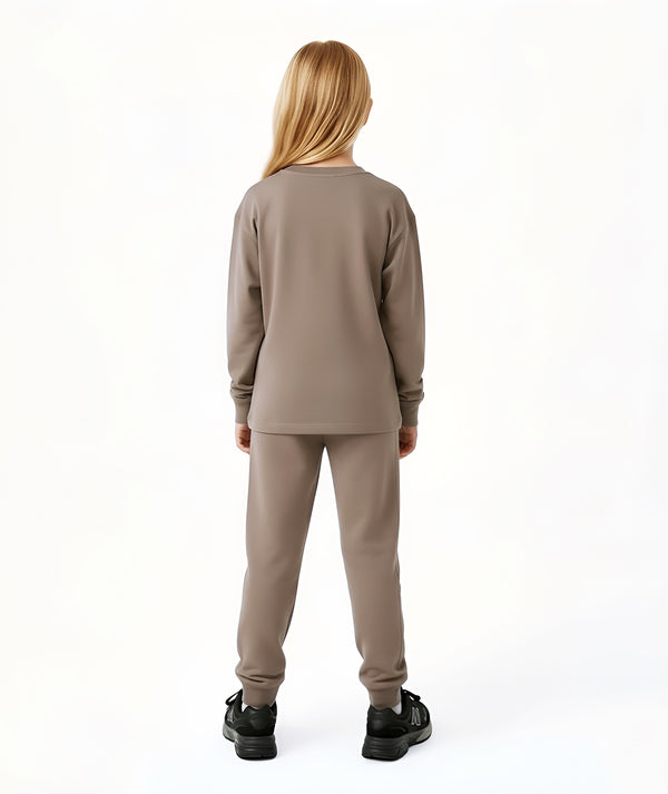 Girl seen from the back wearing a taupe long sleeve top and matching pants, styled for everyday athleisure, school days, and active play, available in sizes 3–14