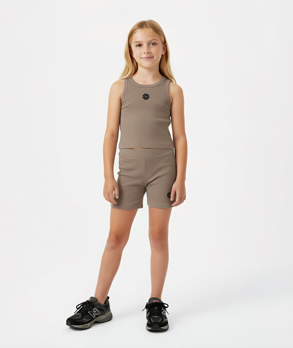 Front-facing lifestyle image of a girl wearing a taupe sleeveless ribbed tank top with matching fitted shorts, styled for warm-weather comfort, light movement, and casual daily wear, available in sizes 3–14