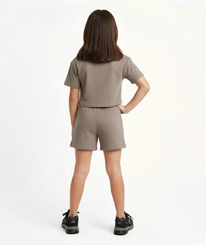 Girl seen from the back wearing a taupe short sleeve t-shirt and matching taupe shorts, styled for everyday athleisure, school days, and active play, available in sizes 3–14