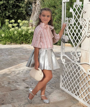 Girl in Mama Luma pink sequin blouse with organza bow, silver metallic skirt, and glitter shoes — luxury girls’ party outfit, perfect for weddings, birthdays, and special celebrations