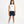Carica l'immagine nel visualizzatore Galleria, Front-facing lifestyle image of a girl wearing a white sleeveless tank top with navy shorts, styled for warm days, easy movement, and casual everyday outfits, available in sizes 3–14
