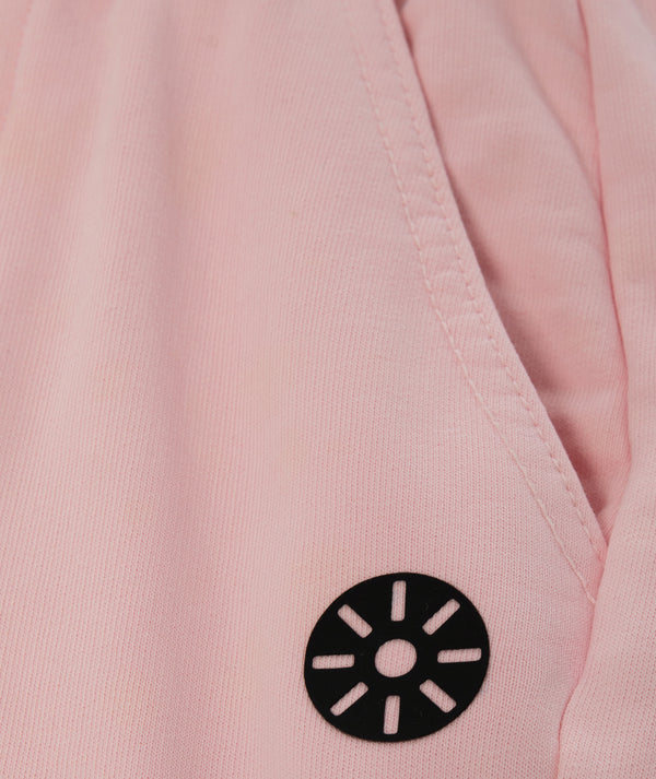 Close-up detail of Goldencubs pink girls sweatpants logo—soft cotton-knit fabric with signature black emblem, ideal for everyday comfort; available in sizes 3–14.