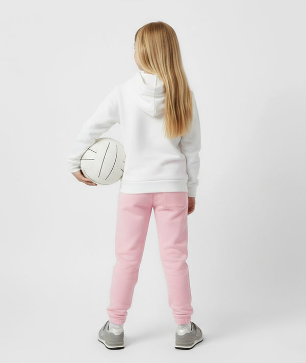 Girl wearing a white GoldenCubs hoodie and pastel pink joggers, shown from the back while holding a volleyball — cozy kids activewear for play, school, and everyday comfort — available in sizes 3–14.