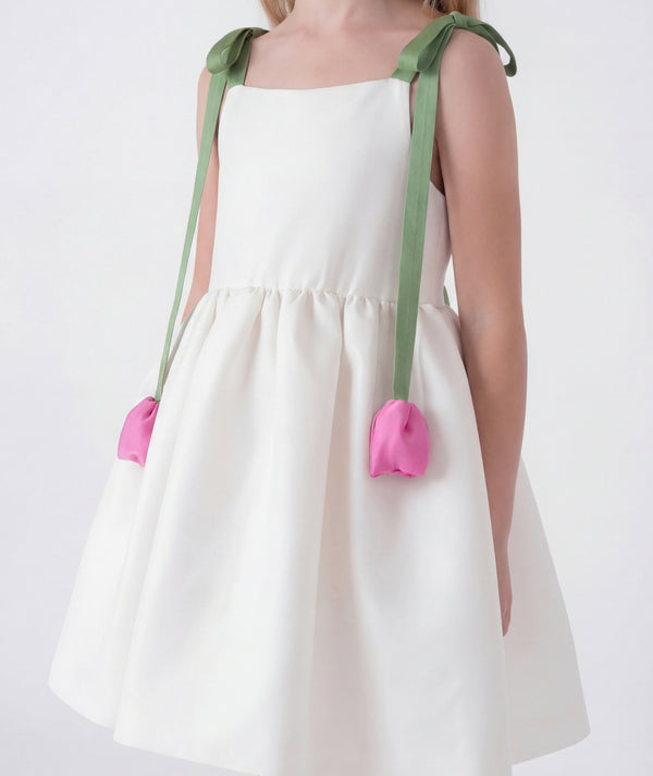 Elegant ivory girls dress featuring soft green shoulder straps with 3D pink tulip accents and a voluminous skirt. A refined special occasion piece designed with delicate structure and timeless charm.