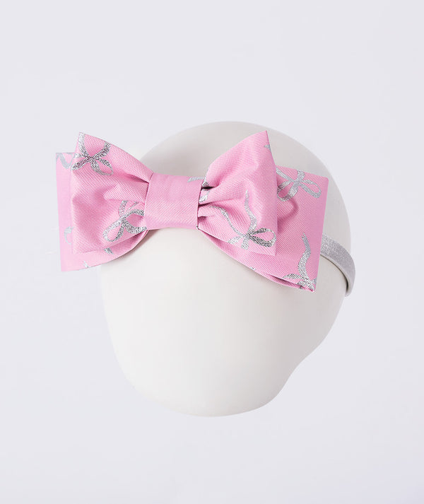 Pink headband with a large bow and silver dragonfly designs on a white background