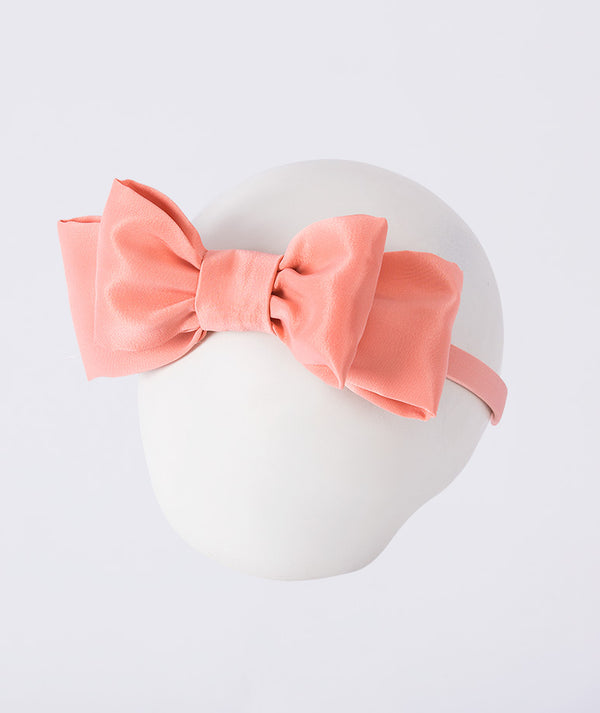 Mahe Lotus Peach Bow Headband featuring a structured peach-toned bow crafted from premium lightweight fabric, designed as an elegant hair accessory for birthdays, weddings, christenings, and special occasions.