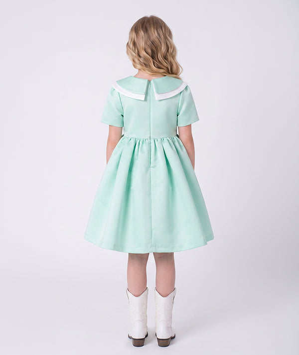 Back view of the Swan Pearl Mint Dress showing the refined collar detail, tailored bodice, and softly flared skirt crafted from breathable lightweight fabric, designed for girls ages 3–12 for Eid celebrations, garden parties, and spring–summer occasions.