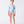 Carica l'immagine nel visualizzatore Galleria, Girl wearing a pastel printed long-sleeve rash guard swimsuit by Mama Luma, featuring ruffle details at the waist and matching swim shoes. The design includes soft pink, mint, and blue tones. Perfect for beach days, poolside fun, and summer vacations. Available in girls’ sizes 3–12 years.
