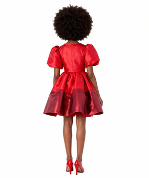 Back view of Mama Luma’s Shimmering Bow Dress for women in red metallic satin, showcasing the voluminous puff sleeves and flared hem. Perfect for Christmas celebrations, holiday dinners, and winter galas. Available in sizes XS–XL for Mommy & Me coordination.