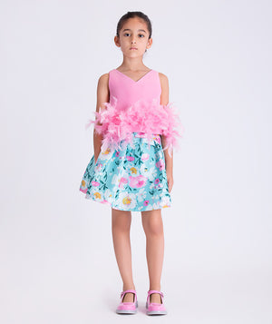 Girl wearing Mama Luma Kohana Feathers two-piece outfit with pink feather top and floral skirt, front view.