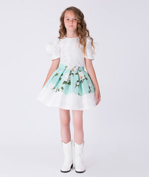Front view of a mint green floral girls occasion outfit featuring a white short sleeve top with puff sleeves and a matching flared skirt, styled for birthdays, weddings, garden parties, and special occasions, available in sizes 3–12