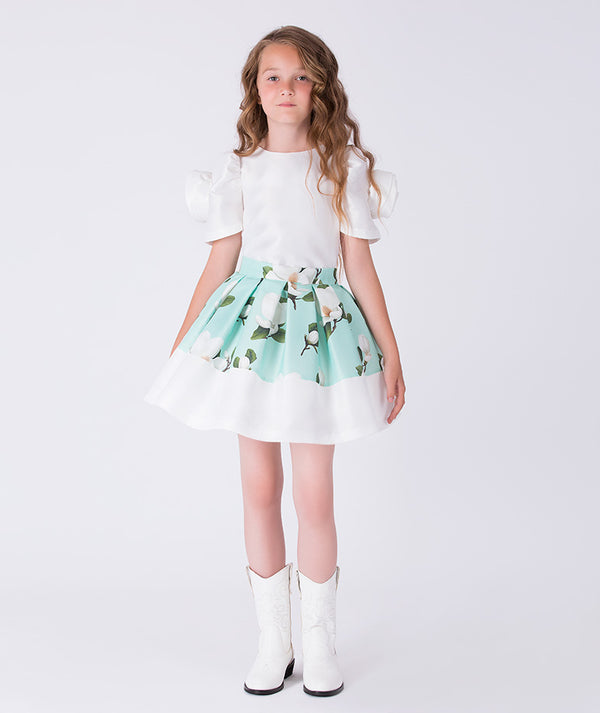 Front view of a mint green floral girls occasion outfit featuring a white short sleeve top with puff sleeves and a matching flared skirt, styled for birthdays, weddings, garden parties, and special occasions, available in sizes 3–12