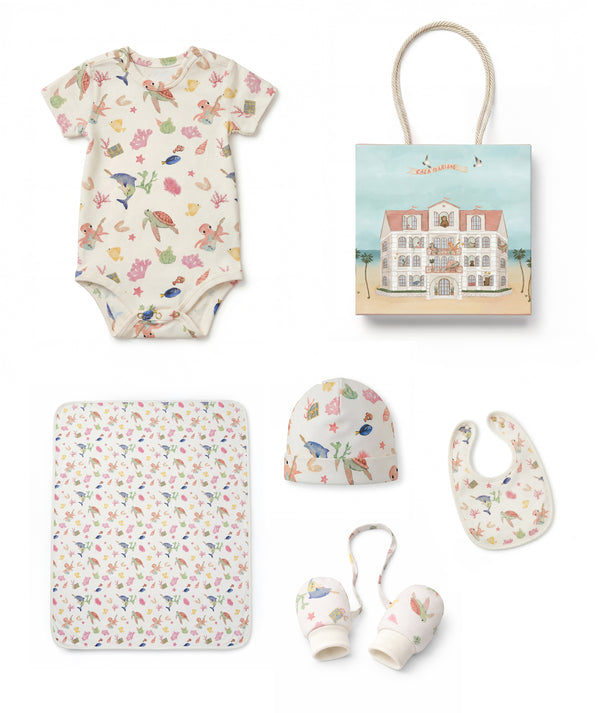 Collection of baby items including a onesie, blanket, teether, and more on a white background.