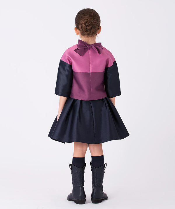 Back view of Mama Luma Orchid Bow Girls Blouse featuring a satin bow detail at the neckline and mulberry and navy matte satin fabric, refined girls blouse for special occasions, ages 3–12Y