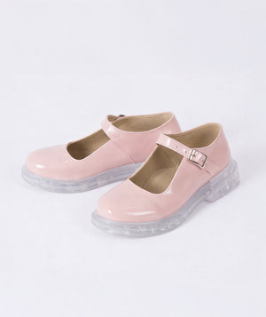 Salmon pink patent leather Mary Jane girls shoes with transparent chunky sole and adjustable buckle strap, elegant glossy finish formal kids footwear on white background.