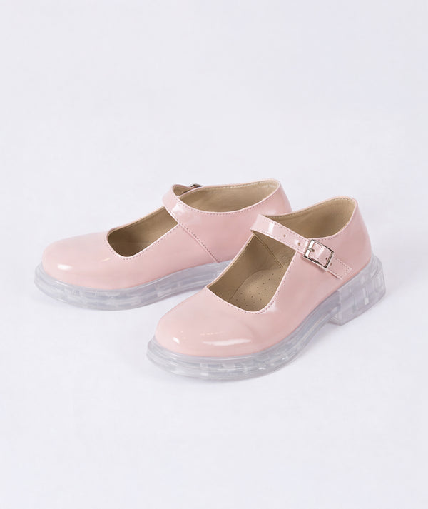 Salmon pink patent leather Mary Jane girls shoes with transparent chunky sole and adjustable buckle strap, elegant glossy finish formal kids footwear on white background.