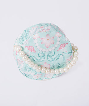 Floral-patterned hat with pearls on a light gray background