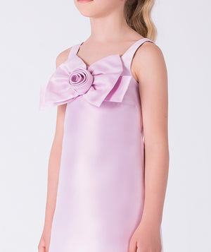 Close-up of the bow and rosette detail on a pink girls dress, showcasing refined craftsmanship and elegant design.