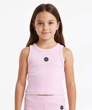 Front-facing close-up of a girl wearing a pink sleeveless ribbed tank top with a minimalist chest emblem, styled for warm-weather comfort, everyday movement, and soft athleisure wear, available in sizes 3–14