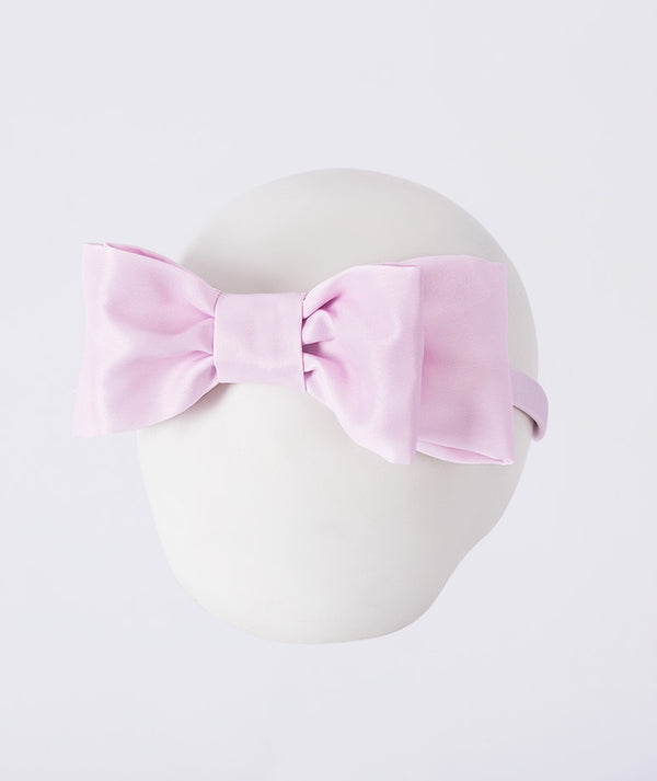 Pink satin bow headband for girls by Mama Luma, styled as an elegant hair accessory for weddings, celebrations, and special occasions.