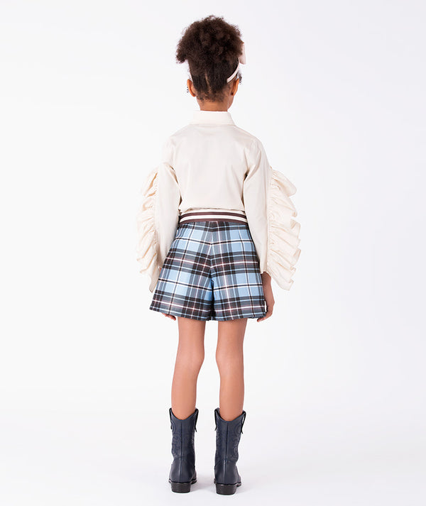 Back view of Pleated Plaid Girls Outfit with cascading ivory sleeve ruffles and powder-blue plaid shorts for girls ages 3 to 12 by Mama Luma.