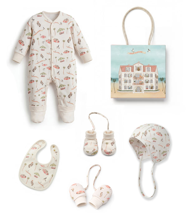 Baby clothing and accessories set including a onesie, bib, booties, and hat on a white background.