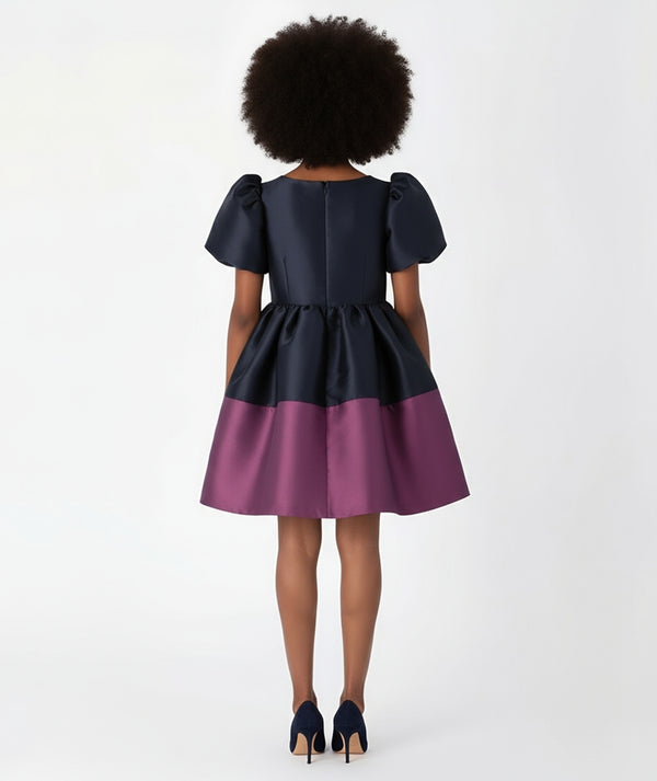 Mama Luma’s Purple Bow Special Occasion Women’s Dress featuring a bold navy and plum color-block design. The oversized bow detail and voluminous silhouette bring couture flair to holiday parties, evening events, and family portraits.