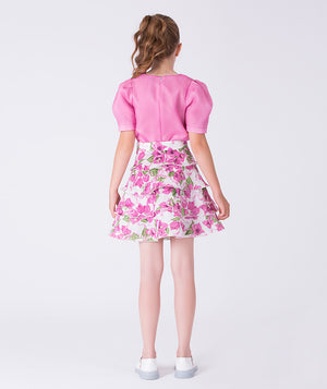 Back view of a two-piece girls outfit with sheer puff sleeves and layered floral skirt, designed for elegant celebrations.