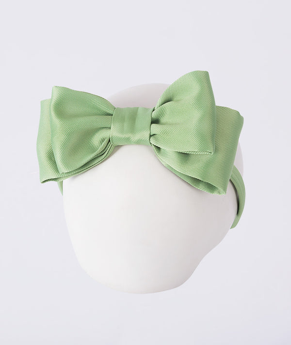 Shimmering bow headband for girls, designed as an elegant hair accessory for special occasions, celebrations, and dress-up moments.