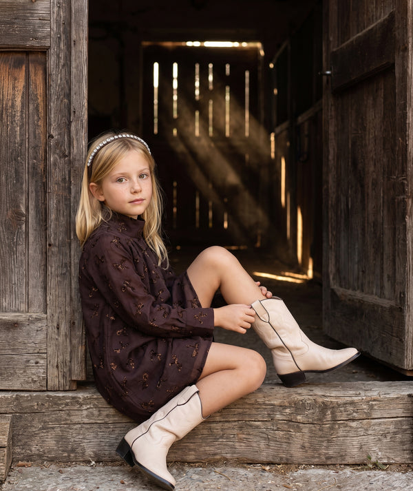Shimmering mocha girls special occasion dress with metallic bow details, high neckline and elegant long sleeves by Mama Luma.