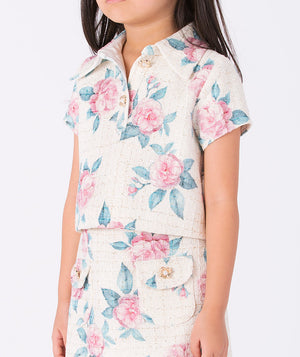 Close-up detail of a floral tweed girls blouse (3–12Y) showing textured fabric, pink rose motifs, and refined button accents for spring events and formal celebrations.