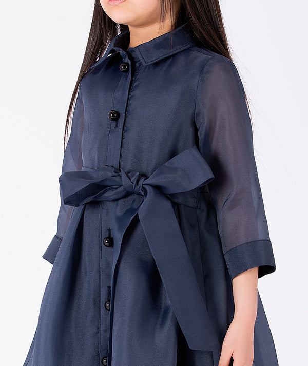 Editorial view of Structured Girls Trench Dress in navy organza for girls ages 3 to 12, styled for weddings, birthdays and special occasions