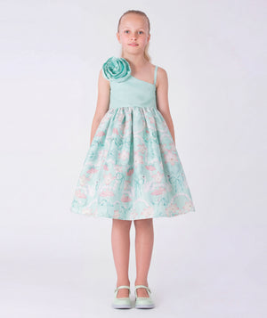 8 YEARS OLD girl in a floral dress standing in an elegant interior setting.