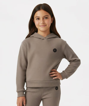 Front-facing cropped lifestyle image of a girl wearing a taupe hoodie styled with ribbed pants, designed for cozy school outfits, relaxed layering, and everyday comfort, available in sizes 3–14