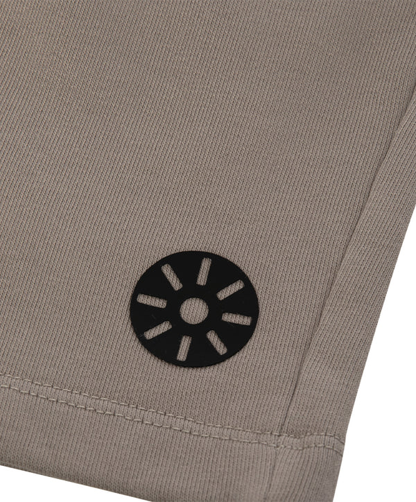 Close-up detail of taupe girls pants highlighting the leg hem stitching and minimalist emblem, designed for everyday wear, school outfits, and casual looks, available in sizes 3–14