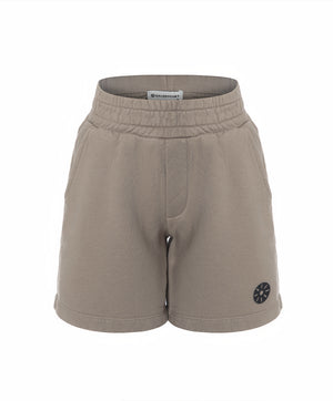 Front view of taupe girls shorts with an elastic waistband and minimalist emblem detail, designed for everyday wear, school outfits, and casual looks, available in sizes 3–14