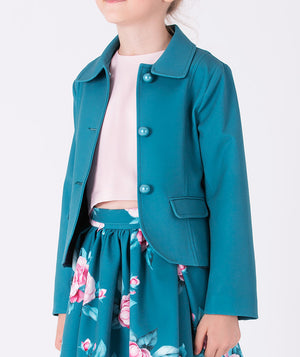 Close-up of teal satin girls’ jacket with pearl buttons, styled with a floral skirt and pink blouse — elegant layering piece for weddings and special occasions (3–12Y)