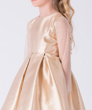 Close-up of sheer dotted tulle long sleeves on gold girls occasion dress with structured bodice.