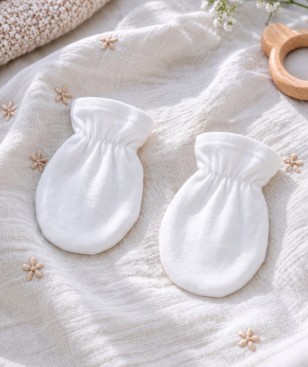 White baby knitwear in a product photograph.