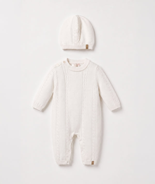Ivory cable knit baby romper with matching beanie luxury newborn knit outfit perfect for special occasions