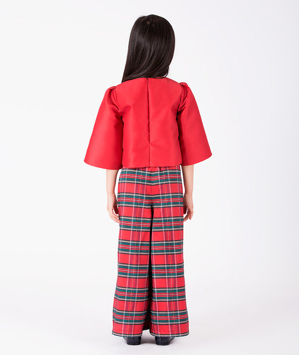 Back view of Mama Luma’s Zermatt two-piece girls outfit showing the concealed zipper, structured red top, and full-length tartan wide-leg trousers.