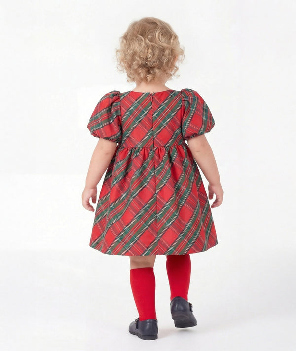 Back view of Mama Luma Zermatt baby girl holiday dress showcasing diagonal tartan checks, voluminous sleeves, and a concealed zipper.