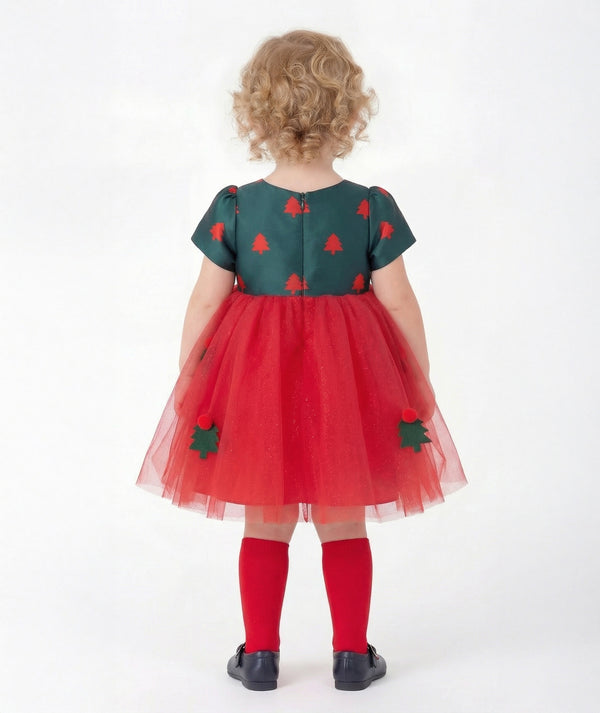 Back view of Mama Luma Zermatt baby girl Christmas dress featuring short puff sleeves, a concealed zipper, and scarlet tulle with festive tree appliqués.